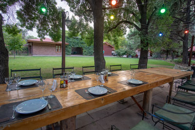 Empty chairs and table against trees