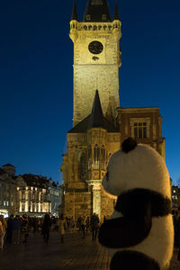 Group of people in front of building against sky at night