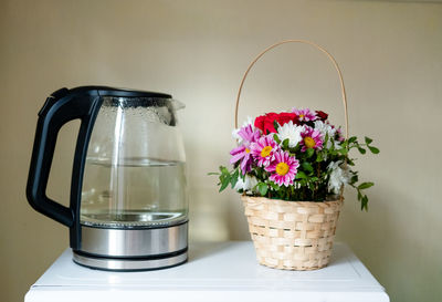 Close-up of flower pot on table against wall