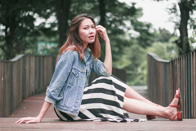 Beautiful young woman sitting outdoors