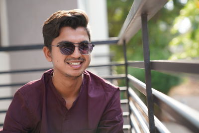 Portrait of young man wearing sunglasses standing outdoors