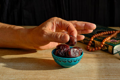 Close-up of hand holding ice cream on table