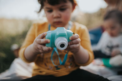 Portrait of cute girl holding camera