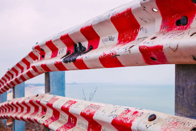 Close-up of multi colored umbrella on metal against sky
