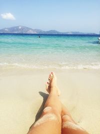 Low section of woman relaxing on beach