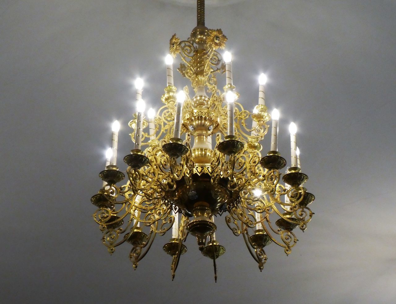 LOW ANGLE VIEW OF ILLUMINATED CHANDELIER HANGING AGAINST CEILING