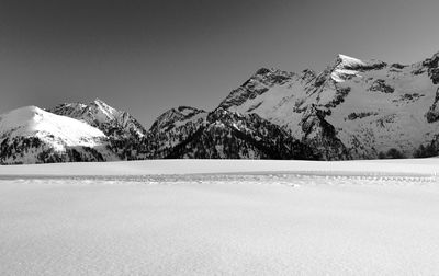 Scenic view of snowcapped mountains against clear sky