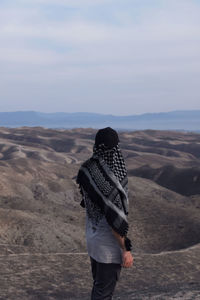 Rear view of woman standing on mountain