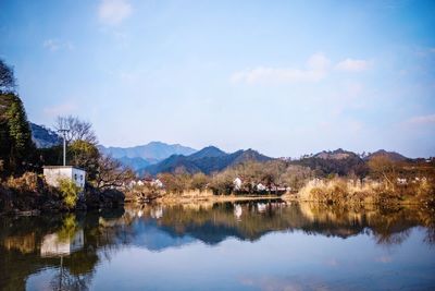 Scenic view of lake by trees against sky