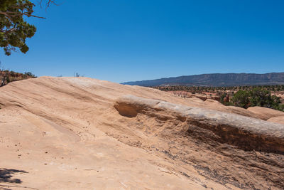 Scenic view of desert against clear blue sky