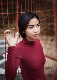 Young beautiful asian woman portrait, metal fence, casual clothes