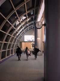 Rear view of people walking in corridor