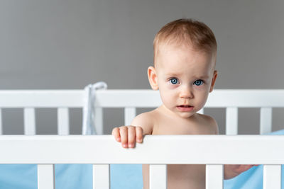 Portrait of cute baby boy sitting on table