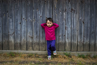 Portrait of girl standing against wall