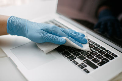 She wipes the keyboard to protect against coronavirus.