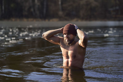 Shirtless man swimming in lake