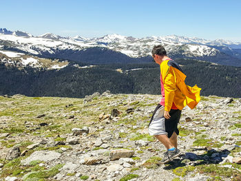 Rear view of woman standing on mountain landscape