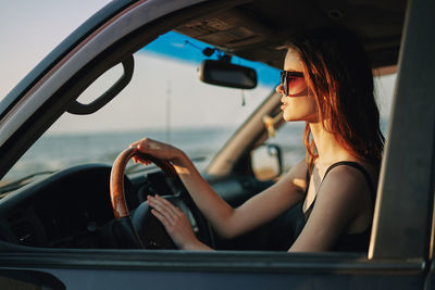 Midsection of woman sitting in car