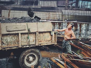 Full length of shirtless man standing outdoors