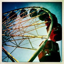 Low angle view of ferris wheel against blue sky