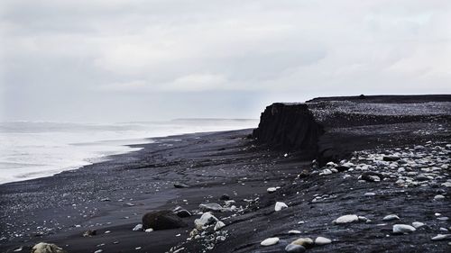 Rocks on beach against sky