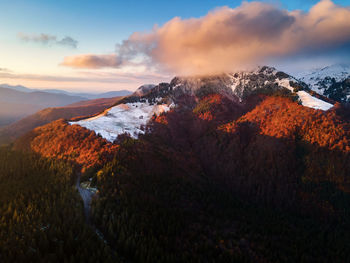 Scenic view of snowcapped mountains against sky during sunset