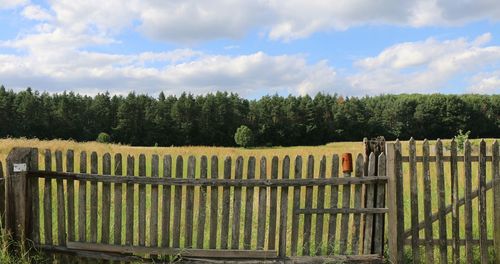 Wooden fence on field against sky