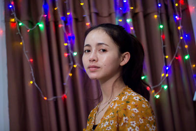 Portrait of woman against illuminated lights