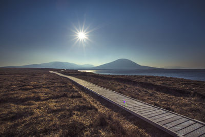 Scenic view of landscape against bright sun