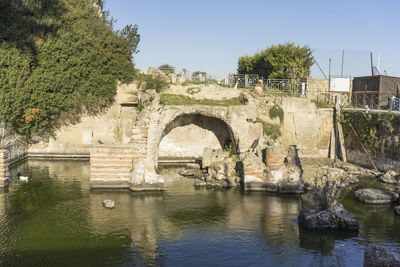 Arch bridge over river against sky