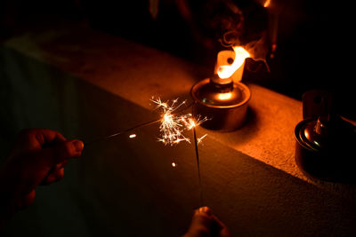 Midsection of woman holding burning candle