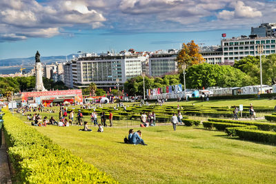 People at park against buildings in city