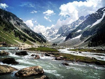 Scenic view of river and mountains against sky