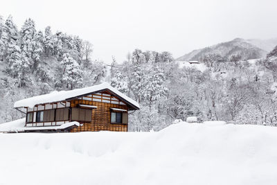 Built structure on snow covered landscape against sky