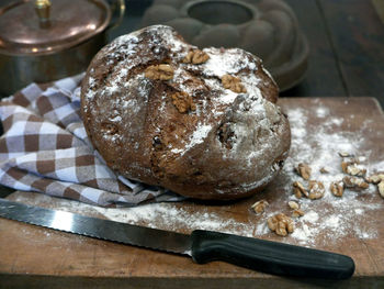 Close-up of bread and flour by knife on cutting board