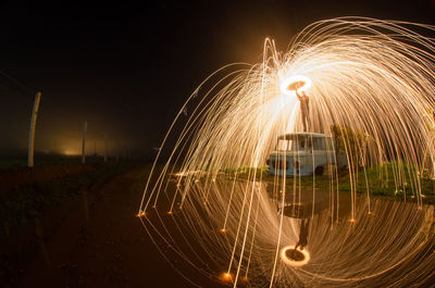 Illuminated ferris wheel against sky at night