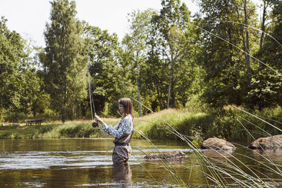 Woman fishing in lake