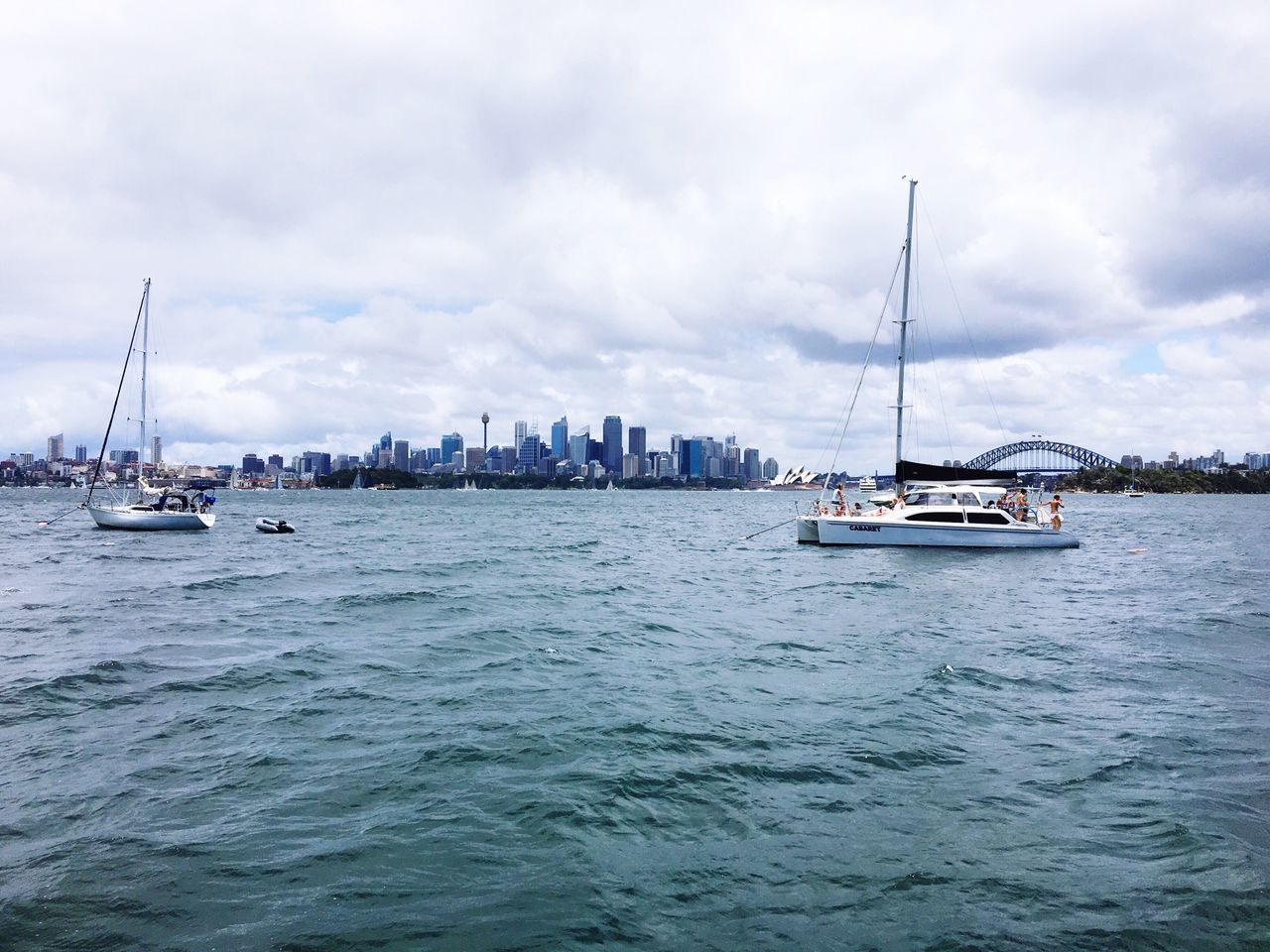 nautical vessel, transportation, water, boat, mode of transport, waterfront, sea, sky, cloud - sky, rippled, sailing, sailboat, mast, moored, building exterior, harbor, ship, city, built structure, cloud