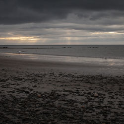Scenic view of beach against sky during sunset