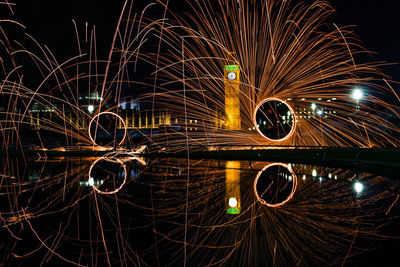 Light trails in city against sky at night