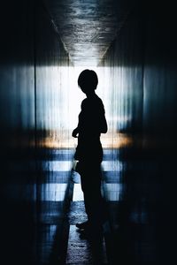 Silhouette man and woman standing by wall