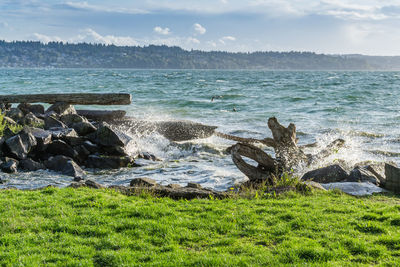 Wave from the puget sound hit rocks on the shoreline in des moines, washington.