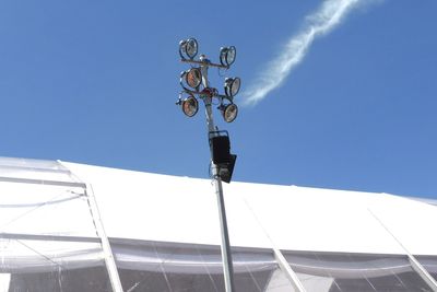 Low angle view of telephone pole against clear blue sky