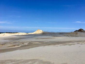 Scenic view of beach against blue sky