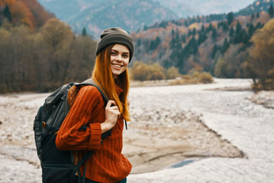 Portrait of smiling young woman standing on land