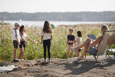 Mother with children relaxing at lake