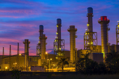 Low angle view of illuminated industry against sky at dusk