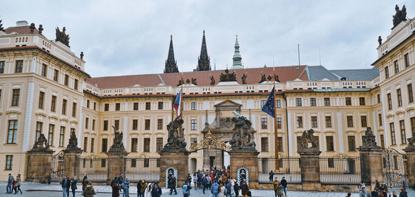 Buildings in city against cloudy sky