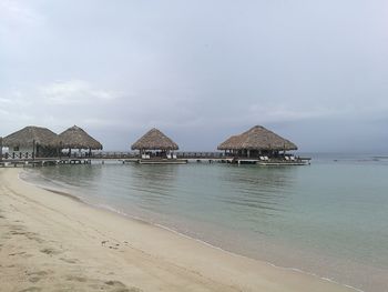 Built structure on beach by sea against sky