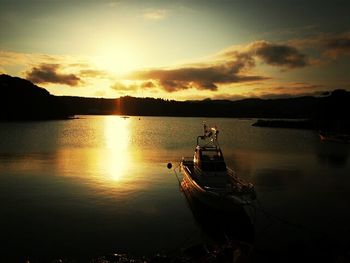 Silhouette boat in sea against sky during sunset